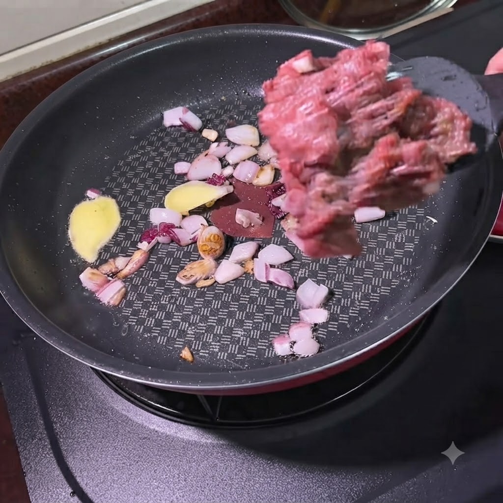 Manzo macinato aggiunto con una spatola in una padella contenente cipolle soffritte e fette di zenzero.
