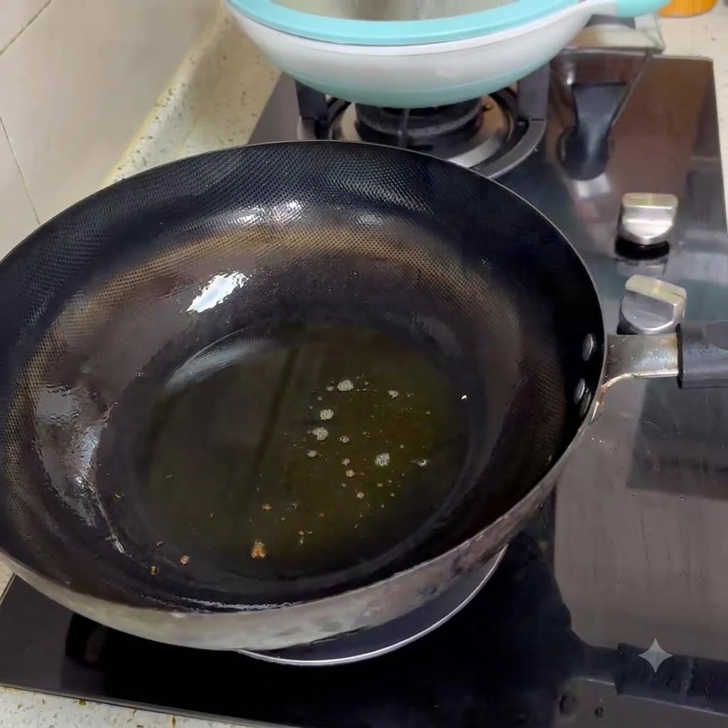 Due cucchiai di pasta di fagioli piccante che friggono in olio caldo allinterno di un wok nero.