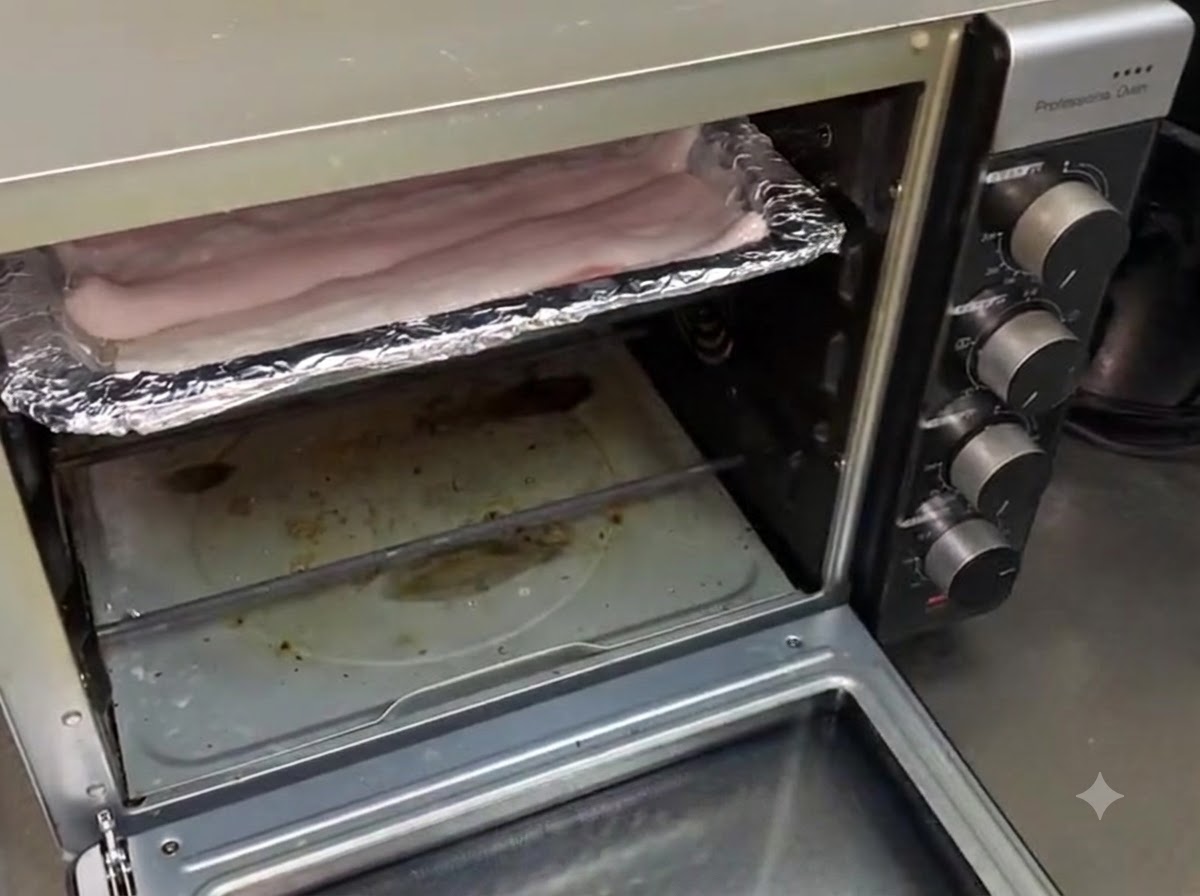 La teglia contenente languilla inserita allinterno di un forno domestico aperto.