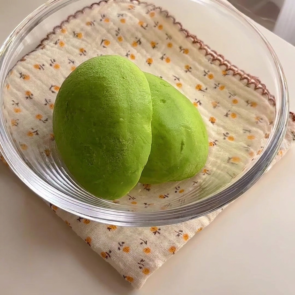 Due metà di avocado verde brillante allinterno di una ciotola di vetro.