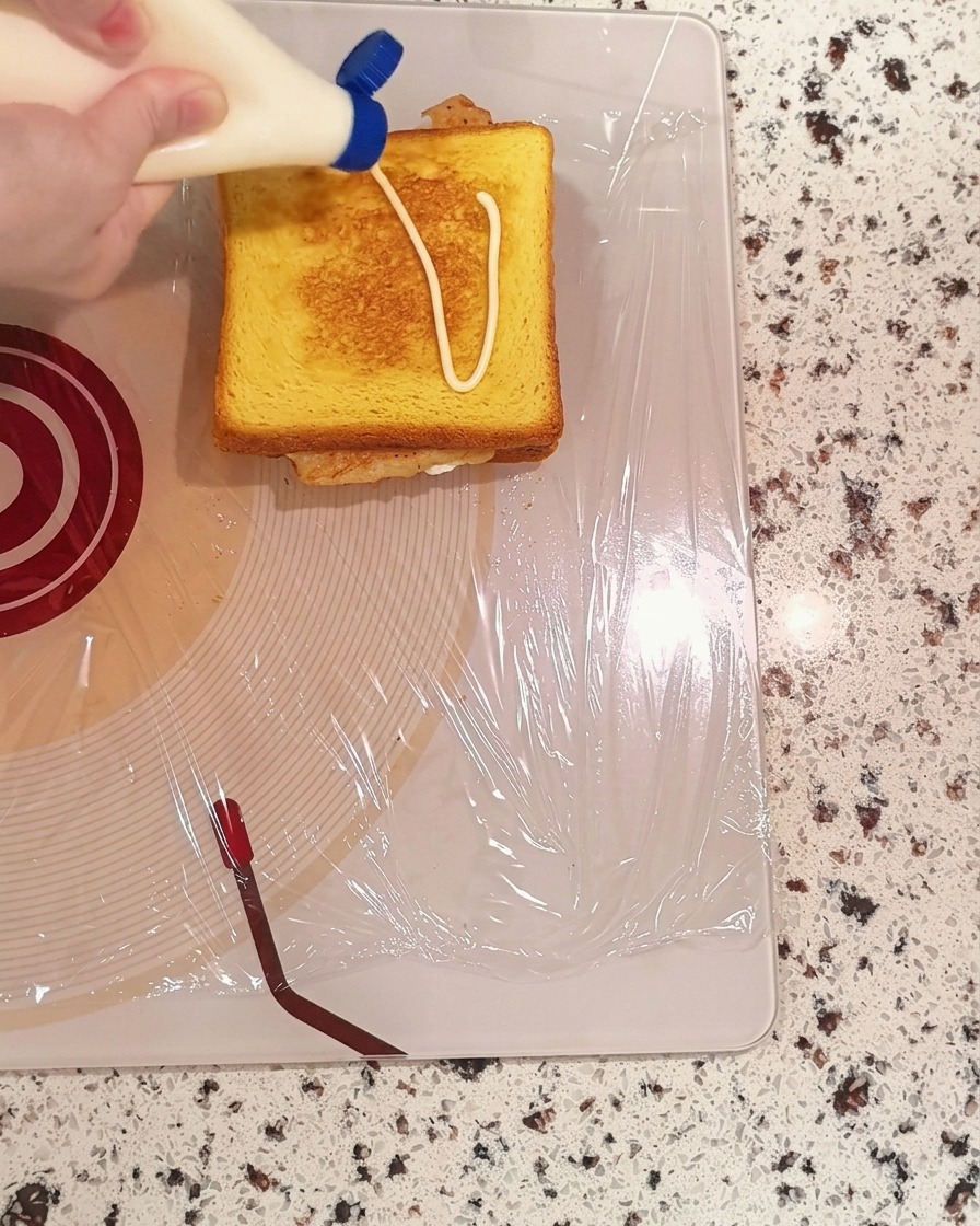 Maionese spremuta a zig-zag su una fetta di pane tostata.