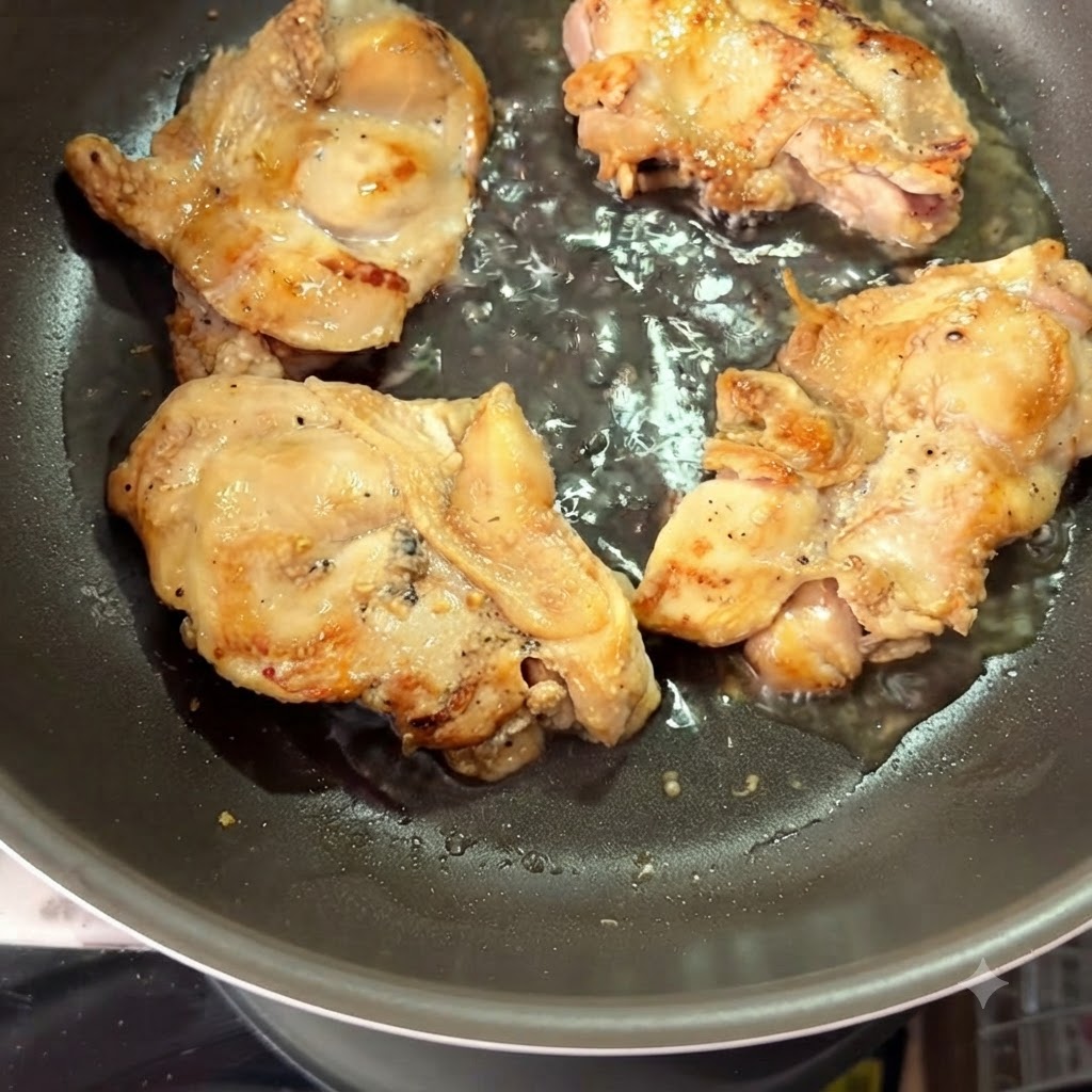 Acqua calda versata in una padella attorno alle cosce di pollo rosolate.