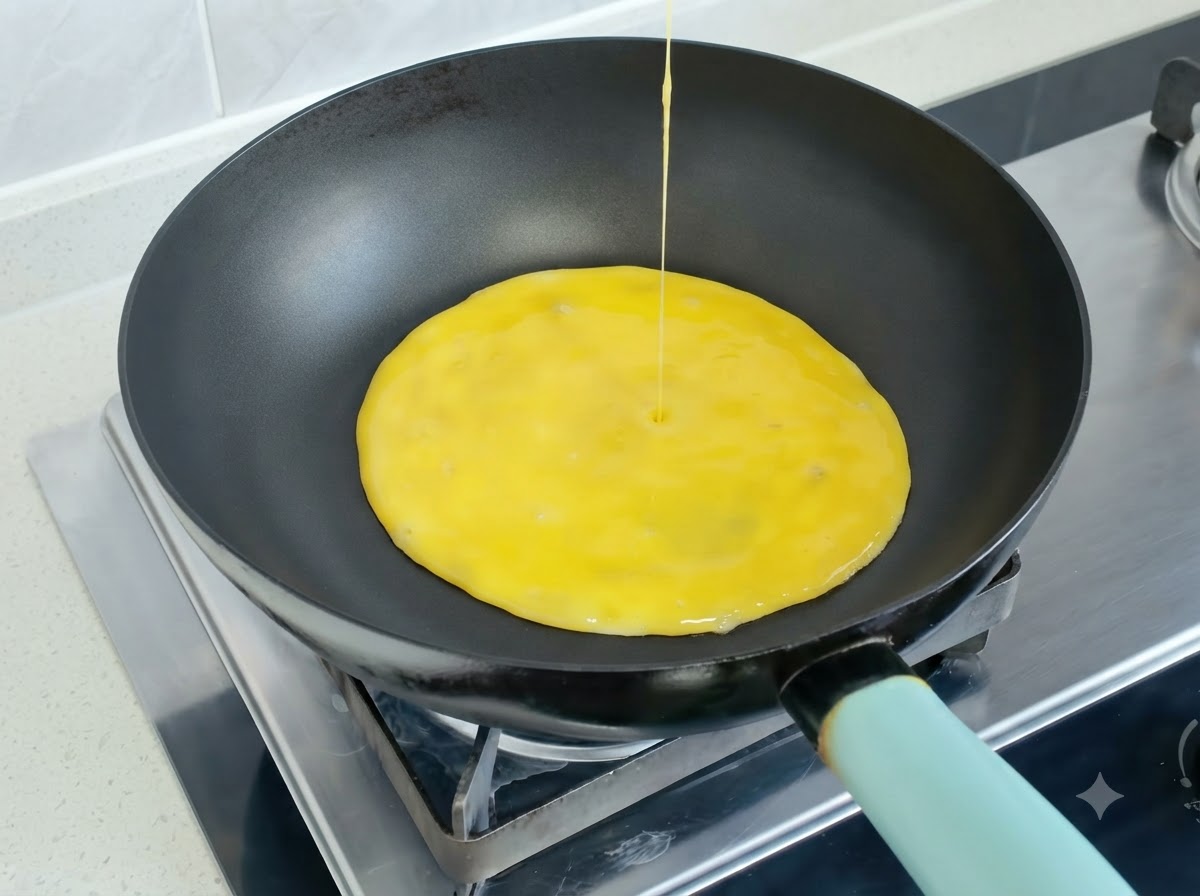 Il composto di uova sbattute versato in una padella calda per formare una frittata.