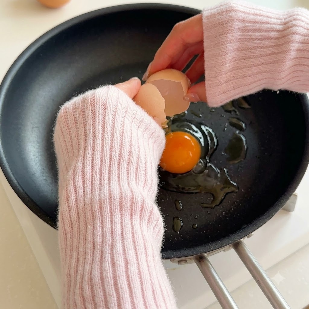 Un uovo che si rompe in una padella calda con olio.
