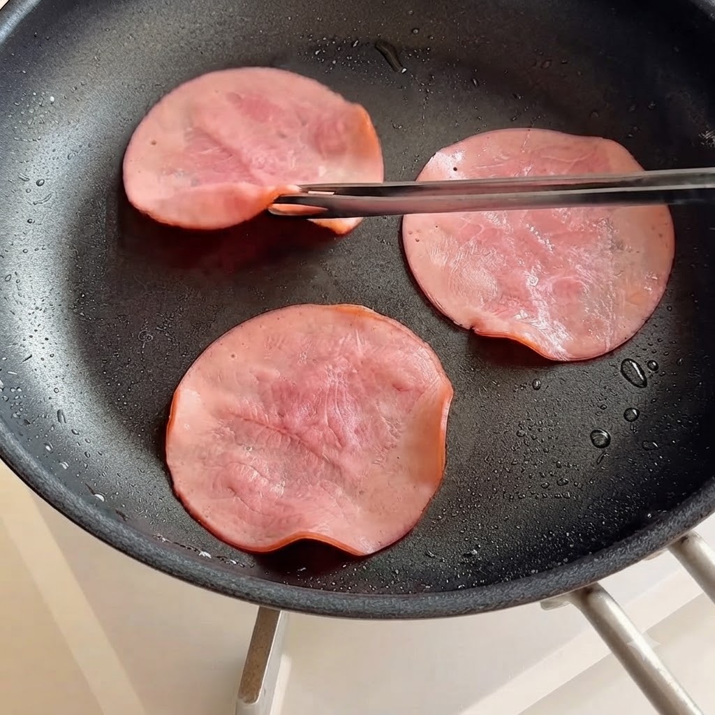 Fette di prosciutto girate in una padella usando le bacchette.
