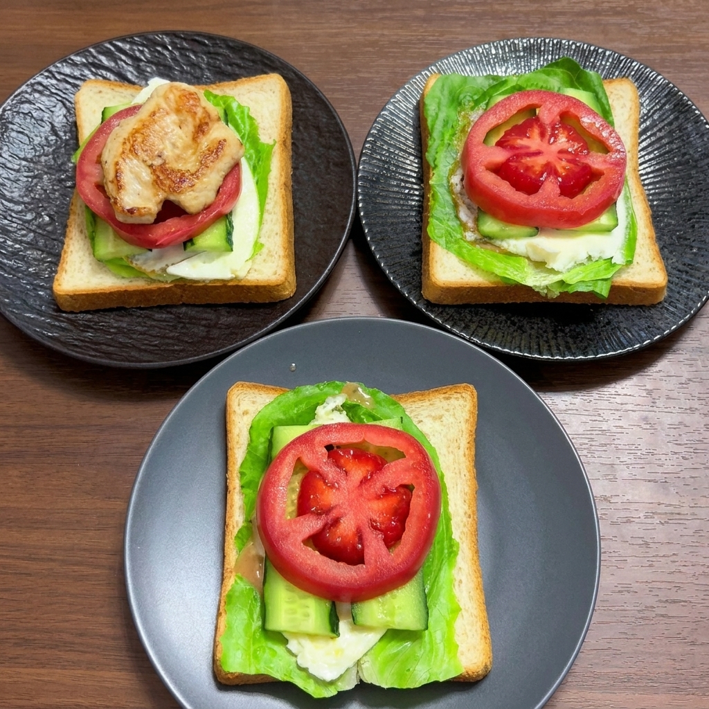 Strati di pane integrale guarniti con insalata, uovo, cetriolo e spesse fette di pomodoro fresco.
