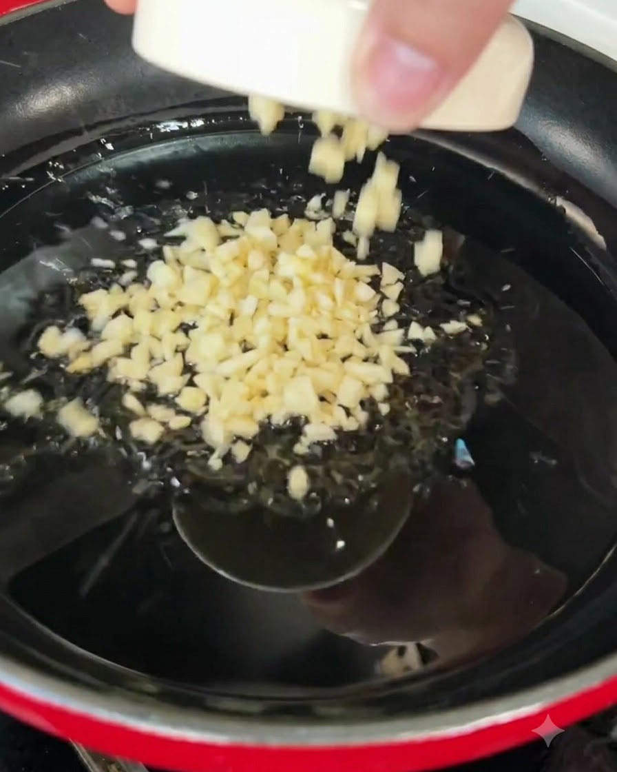 Aglio tritato che sfrigola nellolio doliva caldo allinterno di una padella.