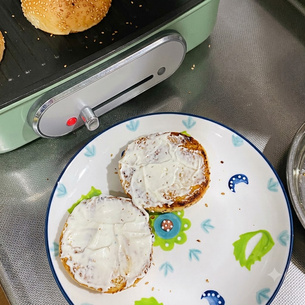 Due metà di panini tostati coperti di maionese appoggiate su un piatto decorato.