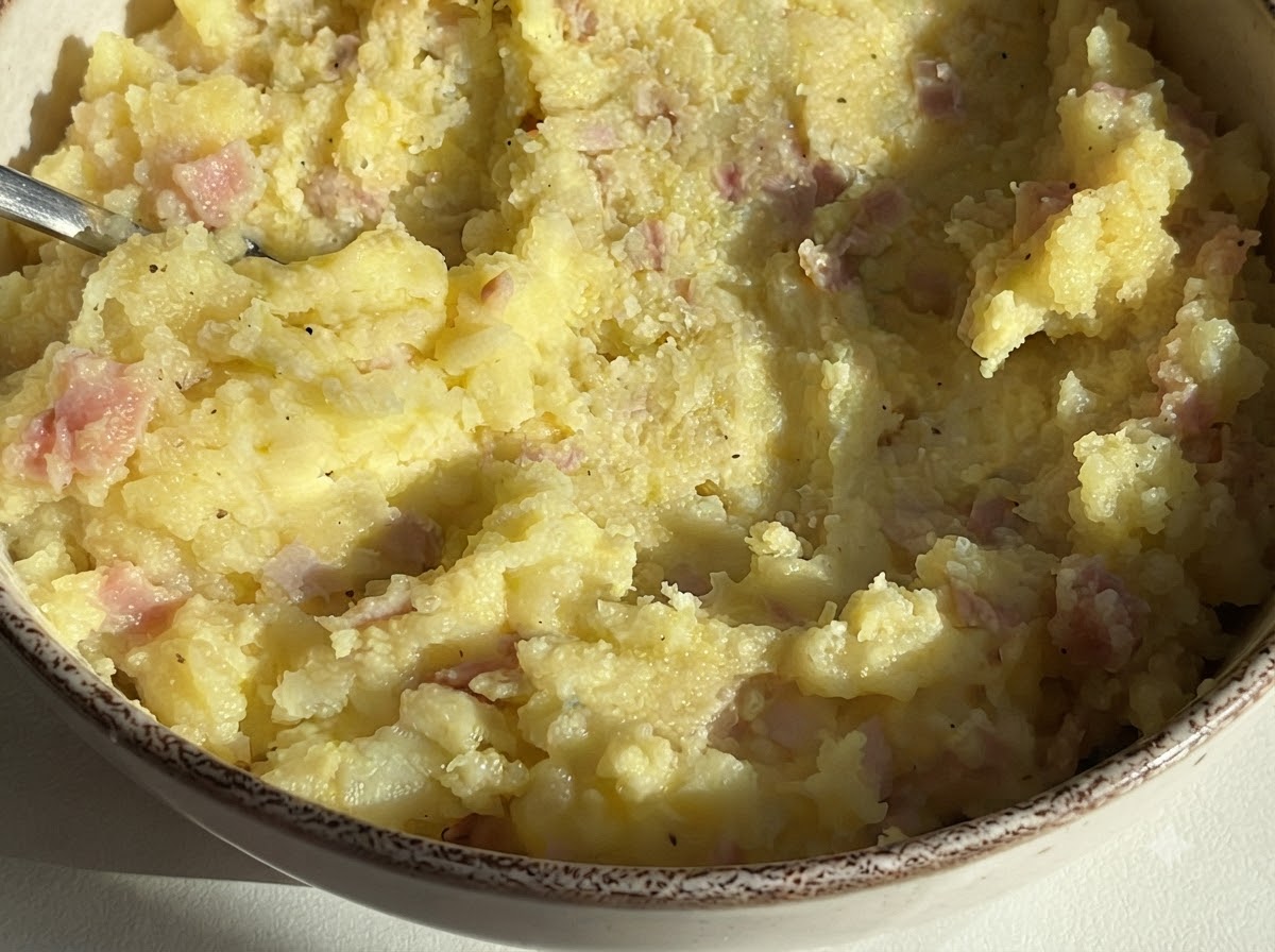 Una ciotola riempita con il composto di patate e prosciutto pronto per la farcitura.