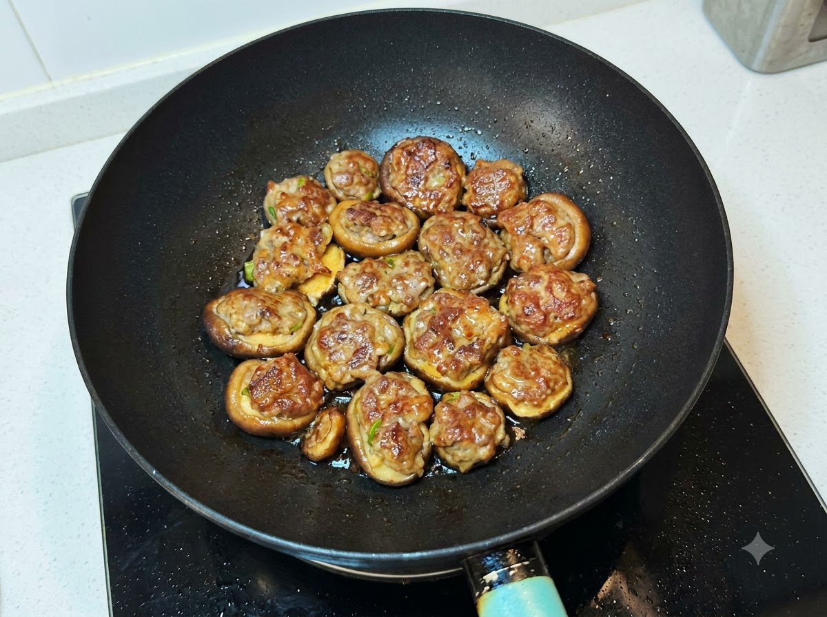 Miscela di salsa versata sui funghi cotti nel wok.