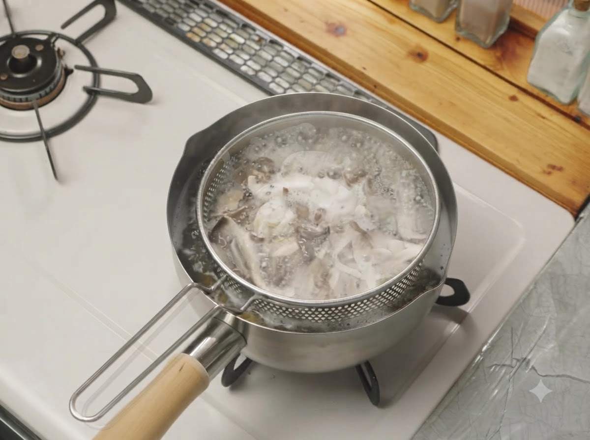 Funghi strappati che bollono dentro un cestino scolapasta inserito in una pentola dacqua sul fuoco.