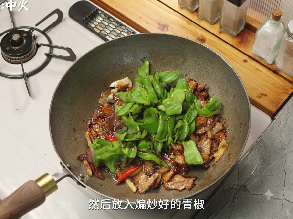 Peperoncini verdi e funghi aggiunti nel wok con il maiale condito.