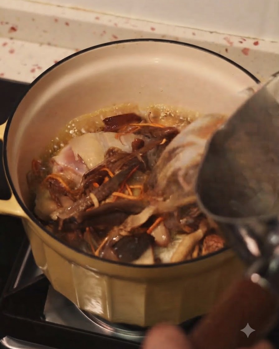 Versare acqua calda da un bollitore in una pentola di pollo rosolato e funghi misti.