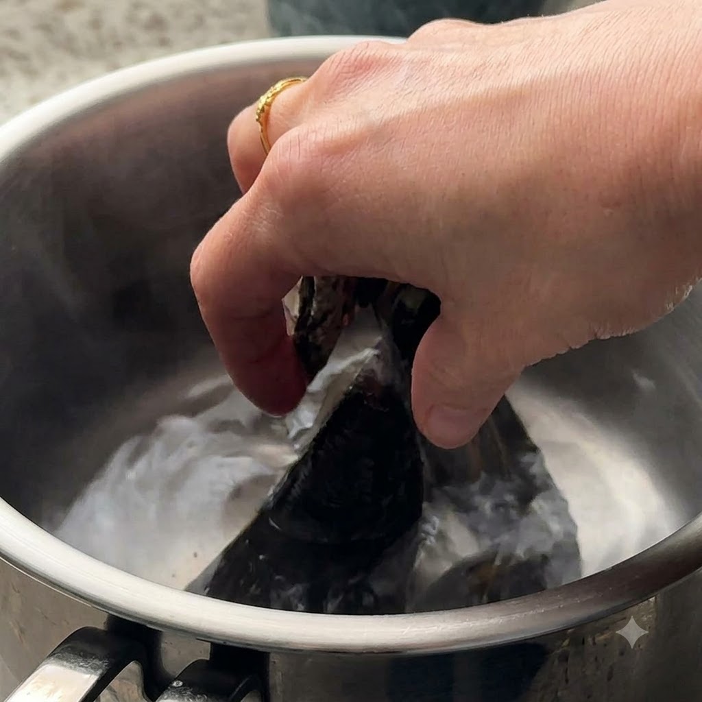 Vongole e cozze verdi messe a bollire in una pentola dacqua.