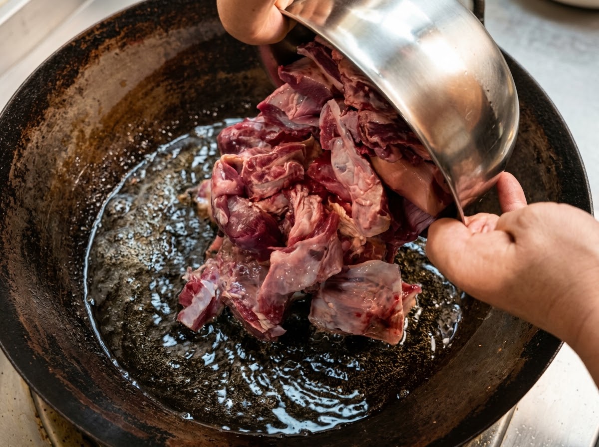 Grandi pezzi di punta di petto di manzo aggiunti allacqua in un wok.