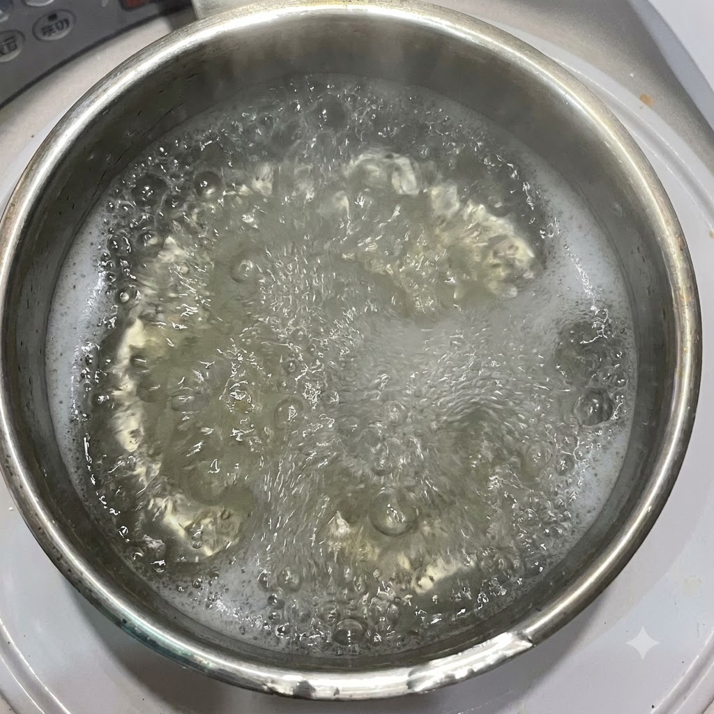 Olio doliva versato in una pentola di acqua bollente contenente pasta penne.