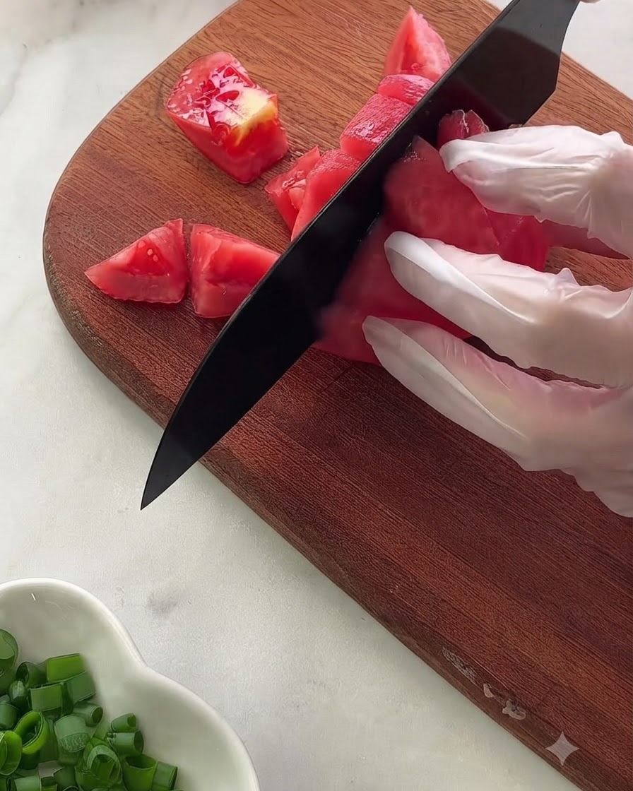 Una vista ravvicinata di vari ingredienti della salsa e condimenti misurati allinterno di una ciotola di vetro poggiata su un panno a pois.