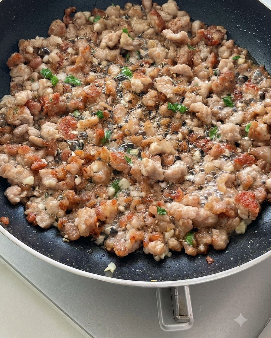 Pomodori a fette saltati con carne macinata e aromi in padella, che iniziano a rilasciare i succhi.