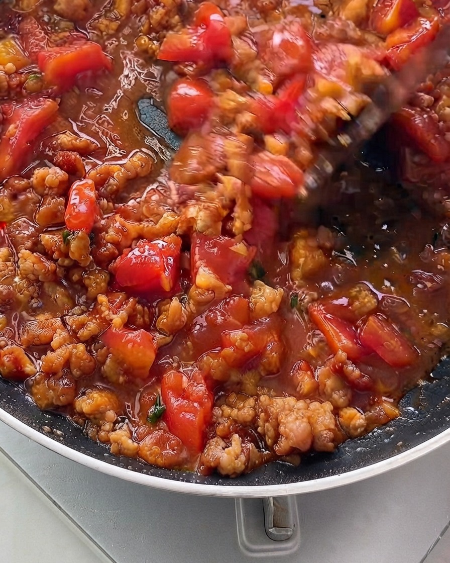 La miscela di salsa che sobbolle e si addensa allinterno di una padella.