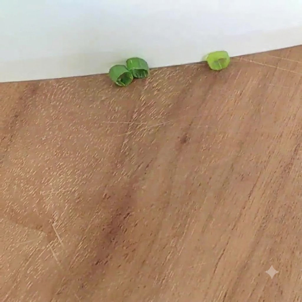 Fette di cipollotto su un tagliere di legno.