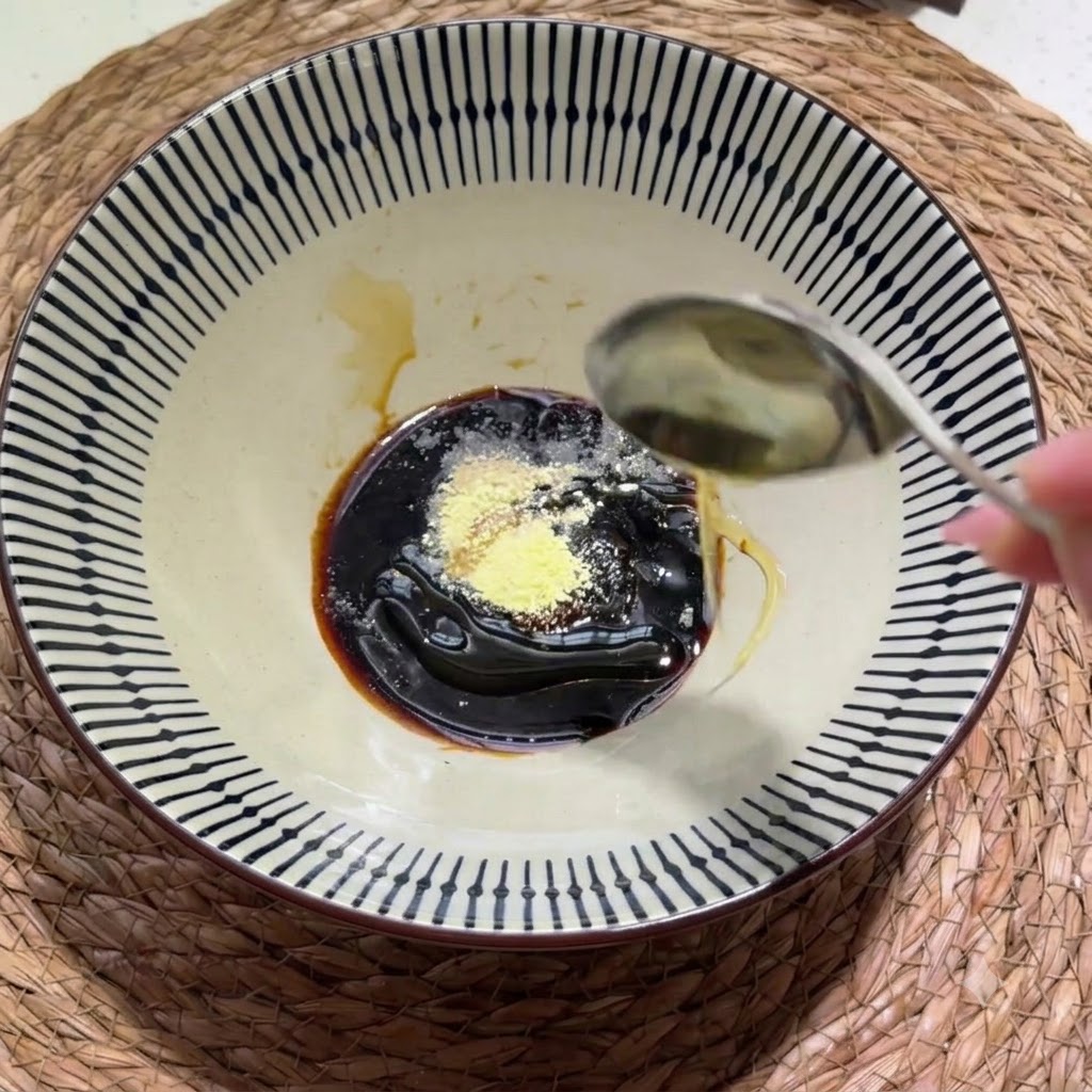 Densa pasta di sesamo e arachidi e un filo dolio di sesamo aggiunti alla ciotola dei condimenti.