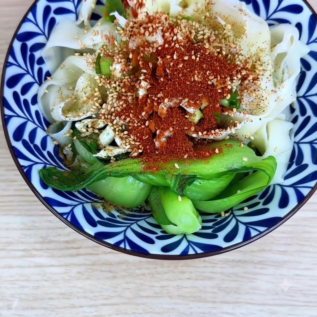 Peperoncino in polvere fine e grossolano cosparso uniformemente sopra i noodles e i condimenti nella ciotola.