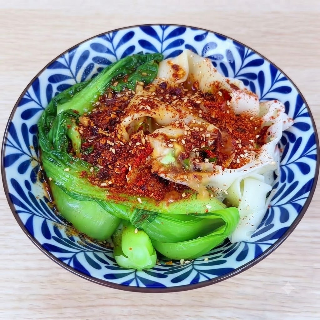 Olio caldo versato sopra il mucchio di peperoncino in polvere e aromi, facendoli sfrigolare allinterno della ciotola.