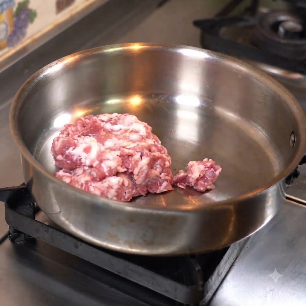 Carne macinata schiacciata piatta in una padella di acciaio inossidabile per cuocere.