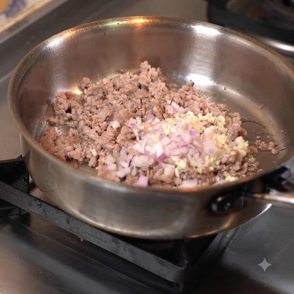 Carne macinata saltata in padella con aglio e cipolle tritati.