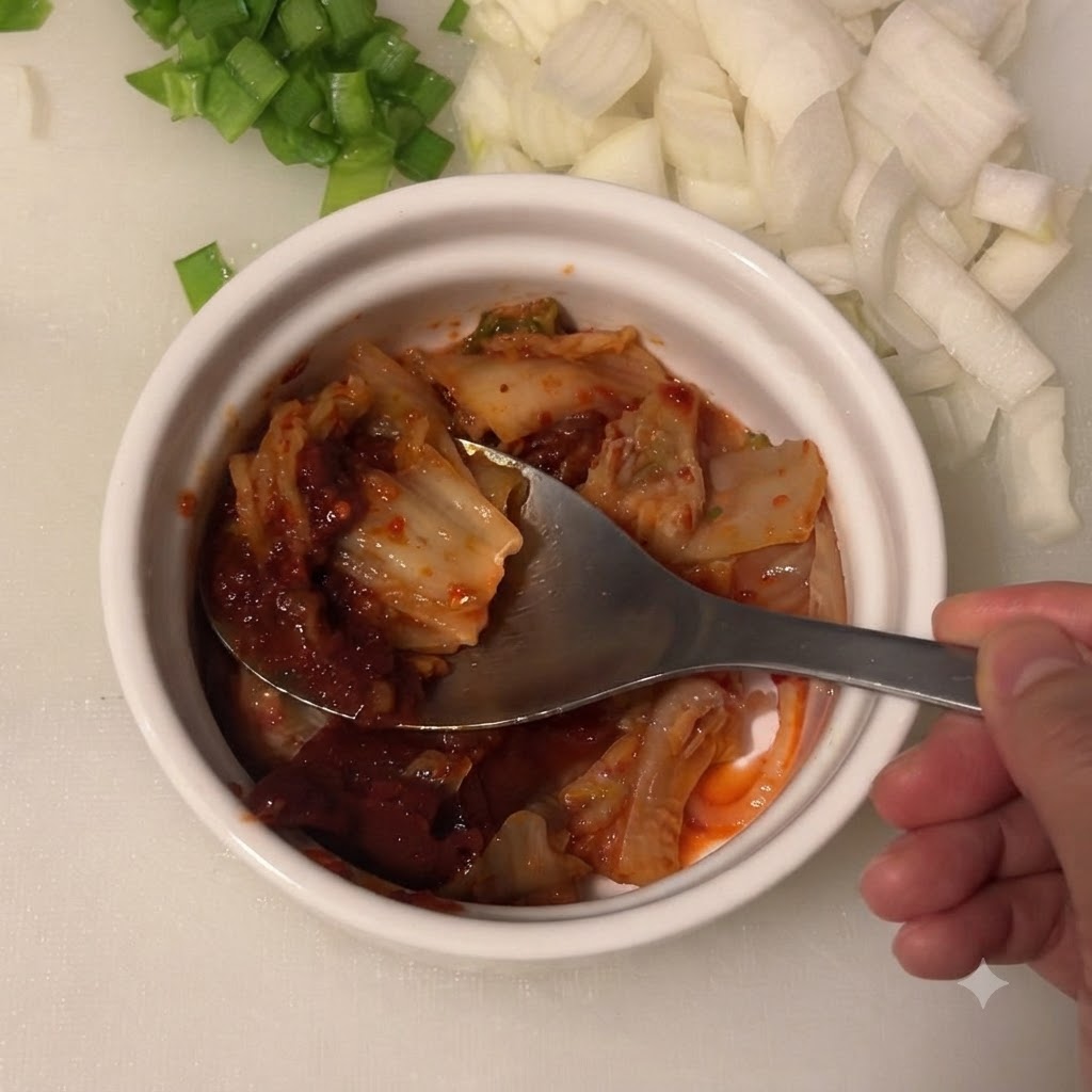 Salsa di soia leggera aggiunta nella ciotola contenente kimchi e pasta di peperoncino coreano.