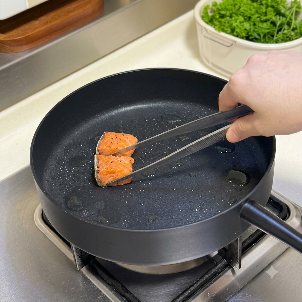 Cubetti di salmone conditi girati in una padella calda con un paio di pinze.