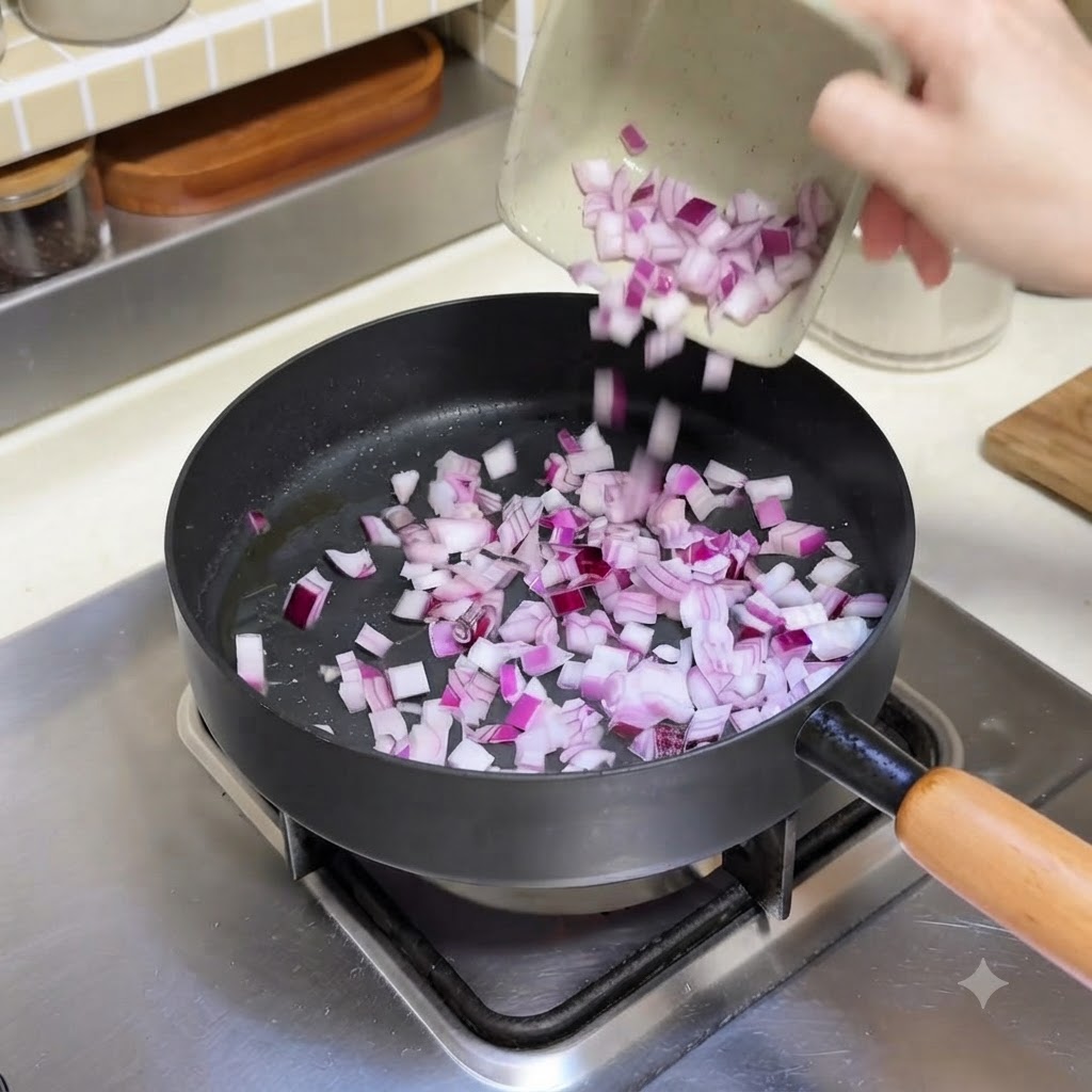 Cipolle rosse a dadini versate da un piccolo piatto in una padella calda con olio.