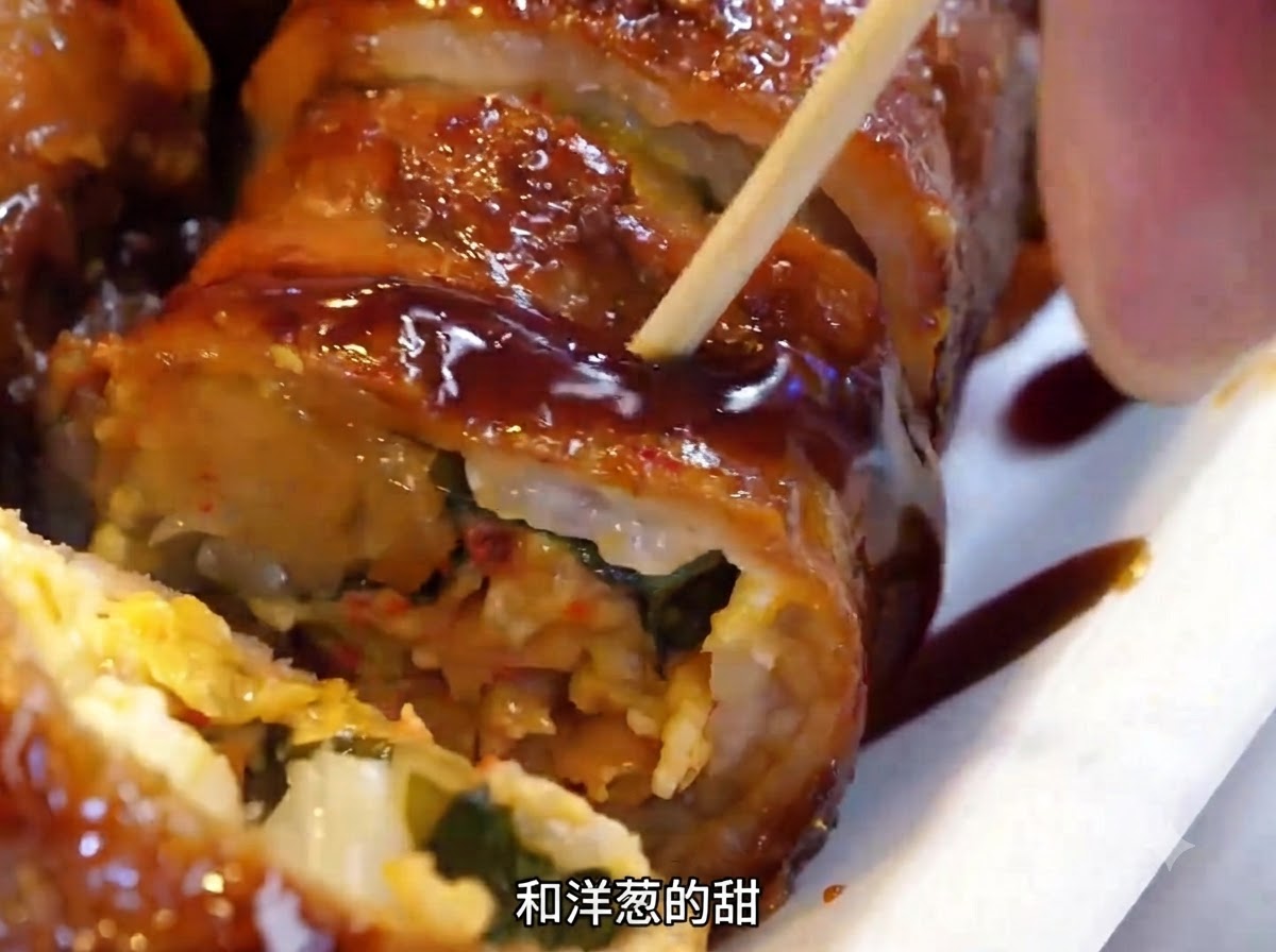 Involtini di carne girati sulla piastra di ferro calda usando una spatola di metallo.