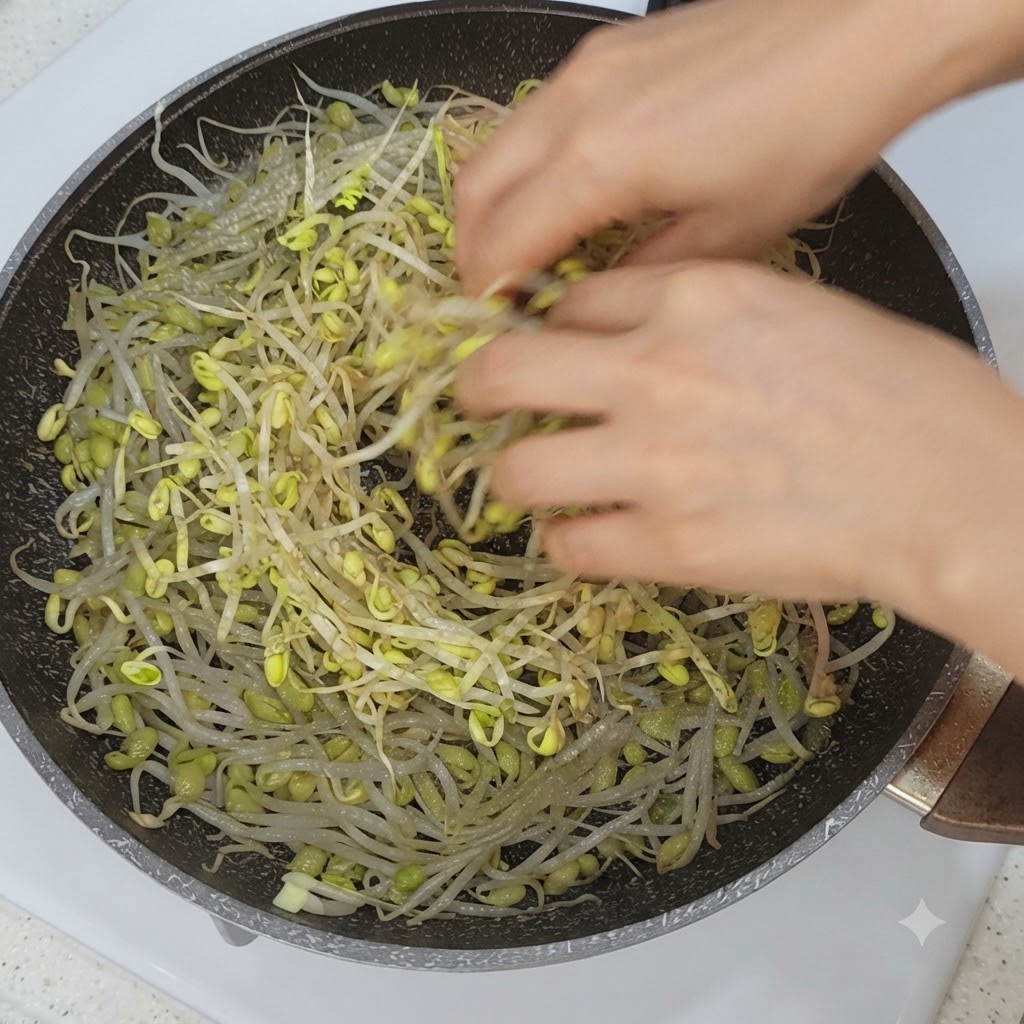 Fette di verdure e pancetta di maiale disposte sopra i germogli di soia in una padella.