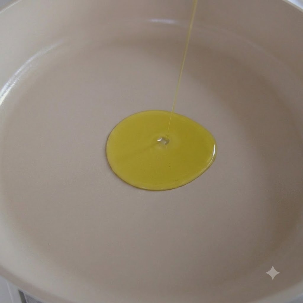 Olio doliva versato in una padella bianca con aglio che soffrigge allinterno.