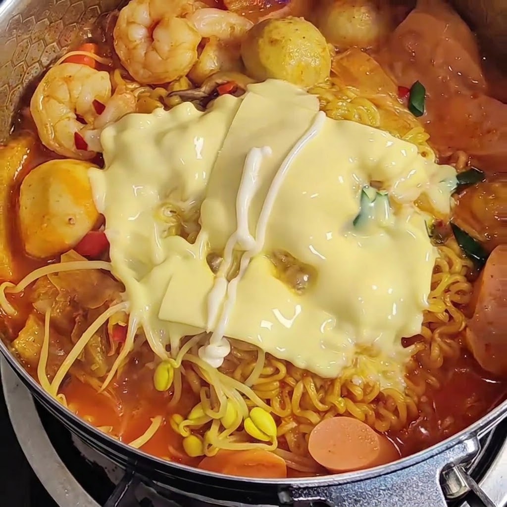 Maionese versata a zig-zag sopra il formaggio fuso in cima ai ramen.