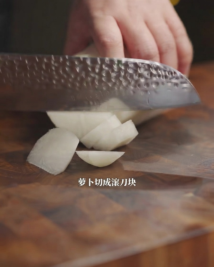 Un coltello da cucina che taglia un ravanello bianco a pezzi su un tagliere di legno.