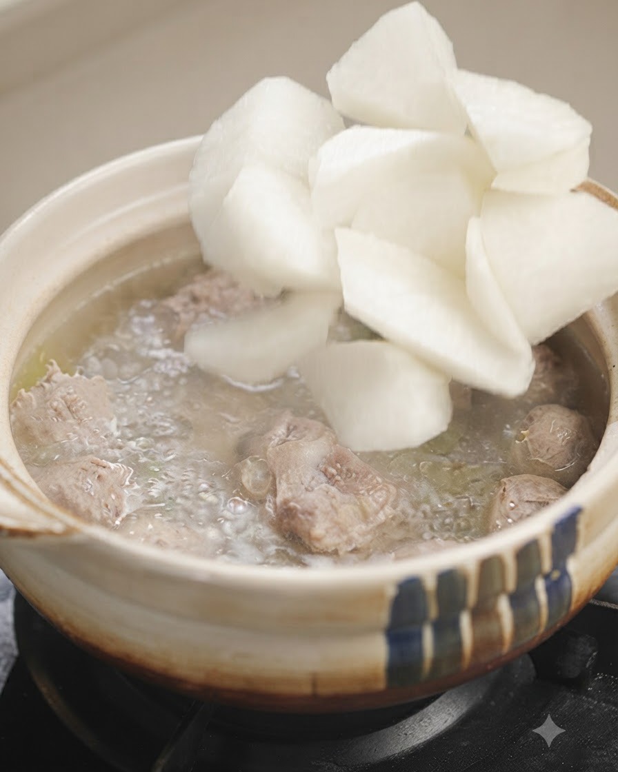 Pezzi di ravanello bianco aggiunti in una pentola di zuppa bollente.