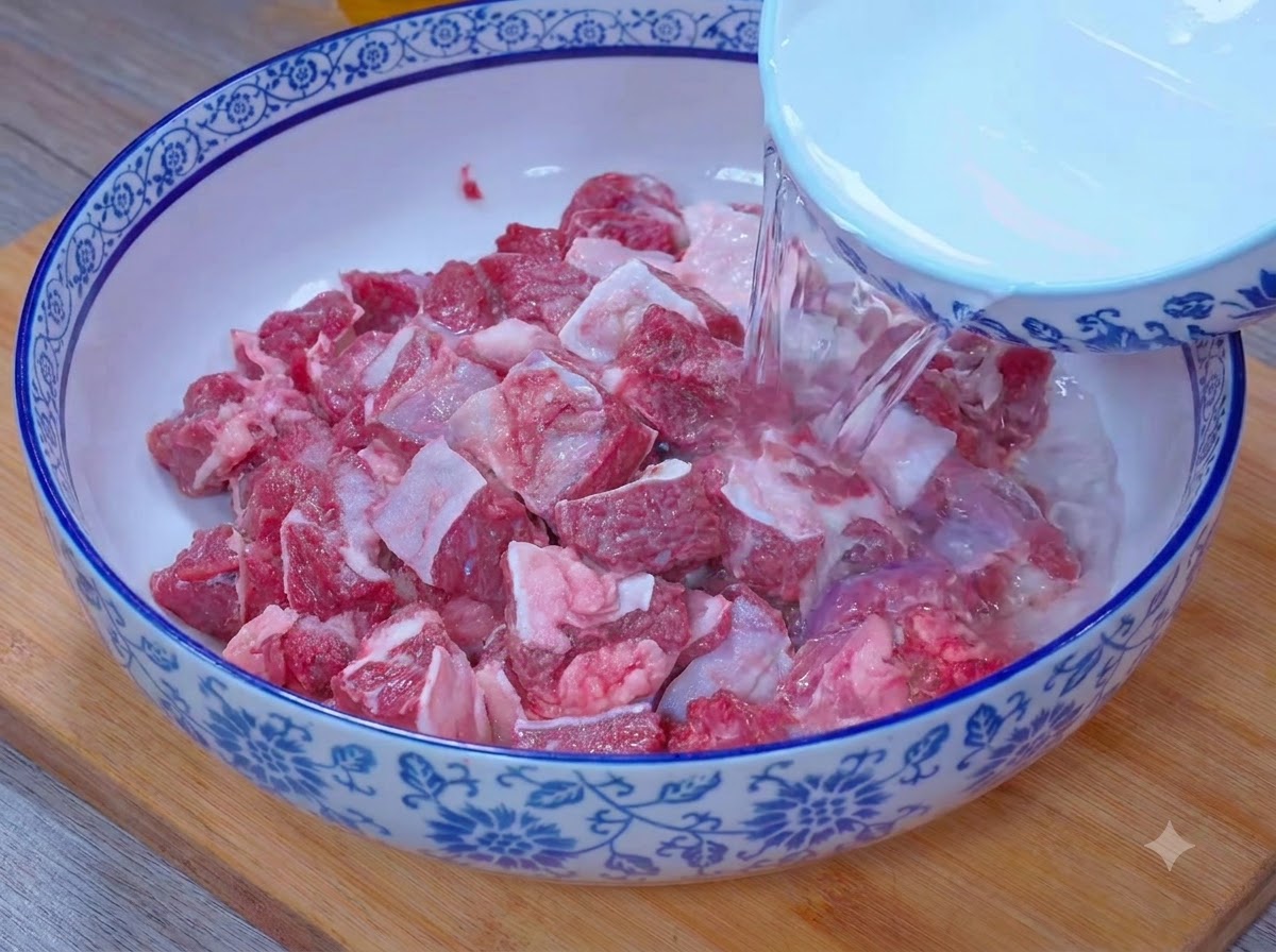 Acqua che scorre da una ciotola per sommergere i pezzi di manzo in una miscela di sale e aceto.