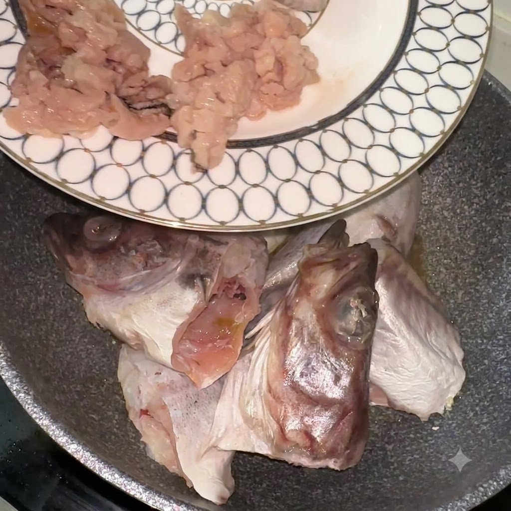 Pezzi e teste di merluzzo trasferiti da un piatto decorato in una padella.