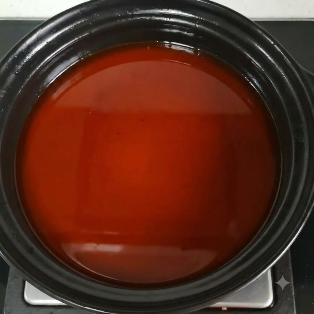 Salsa di pesce mescolata nel brodo di zuppa marrone-rossastro nella pentola.