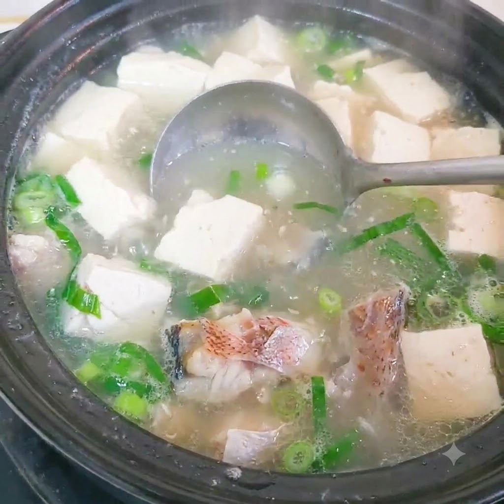 Tranci di pesce sbollentati in una pentola di acqua calda.