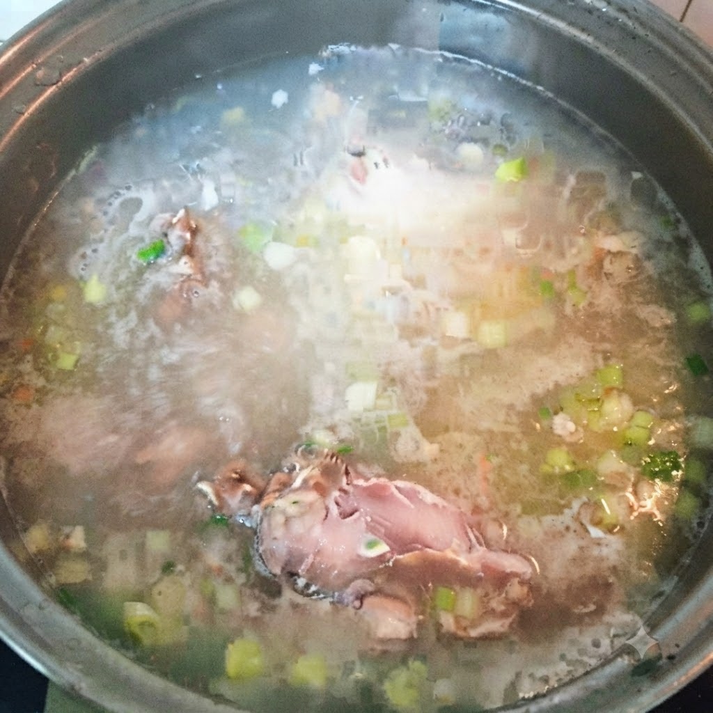 Pezzi di pesce rimanenti aggiunti al brodo di zuppa bollente.