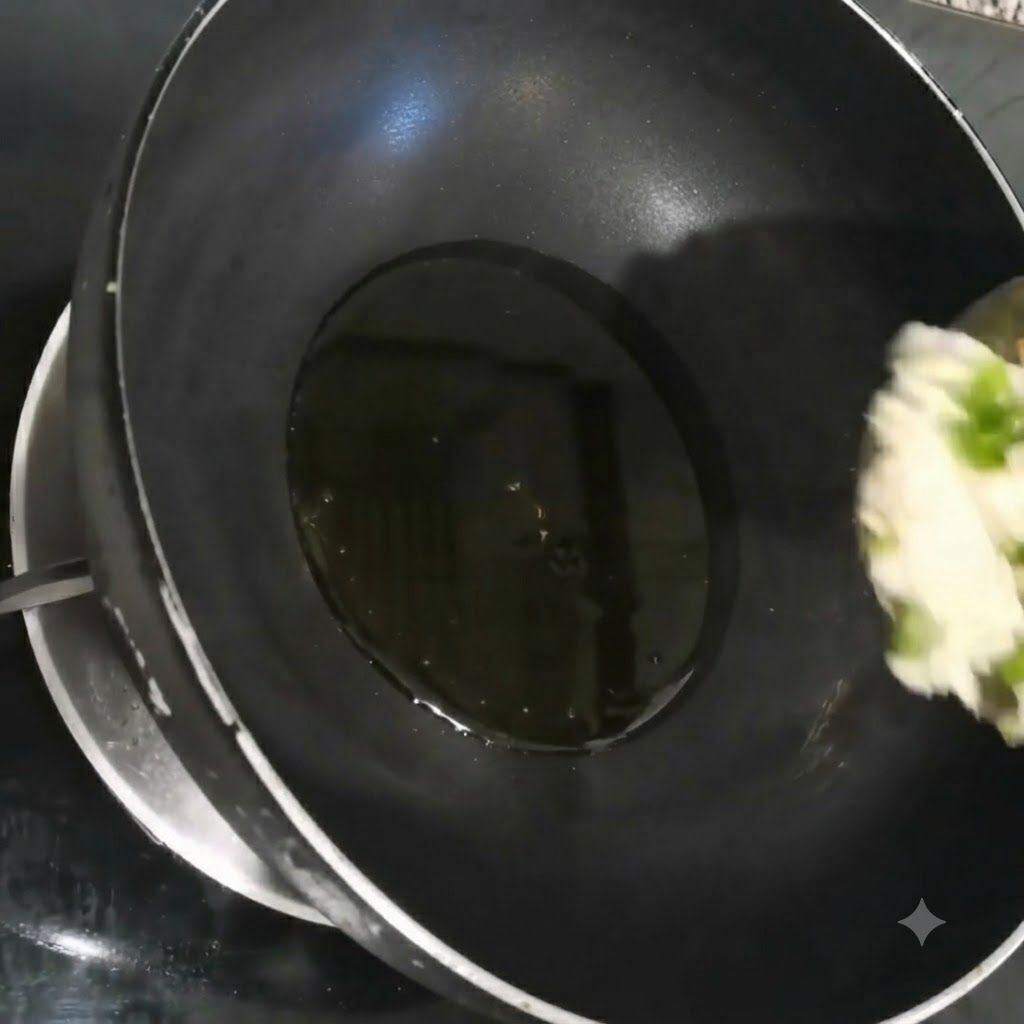 Cipollotti, aglio e coriandolo tritati finemente che sfrigolano nellolio caldo allinterno di un wok nero.