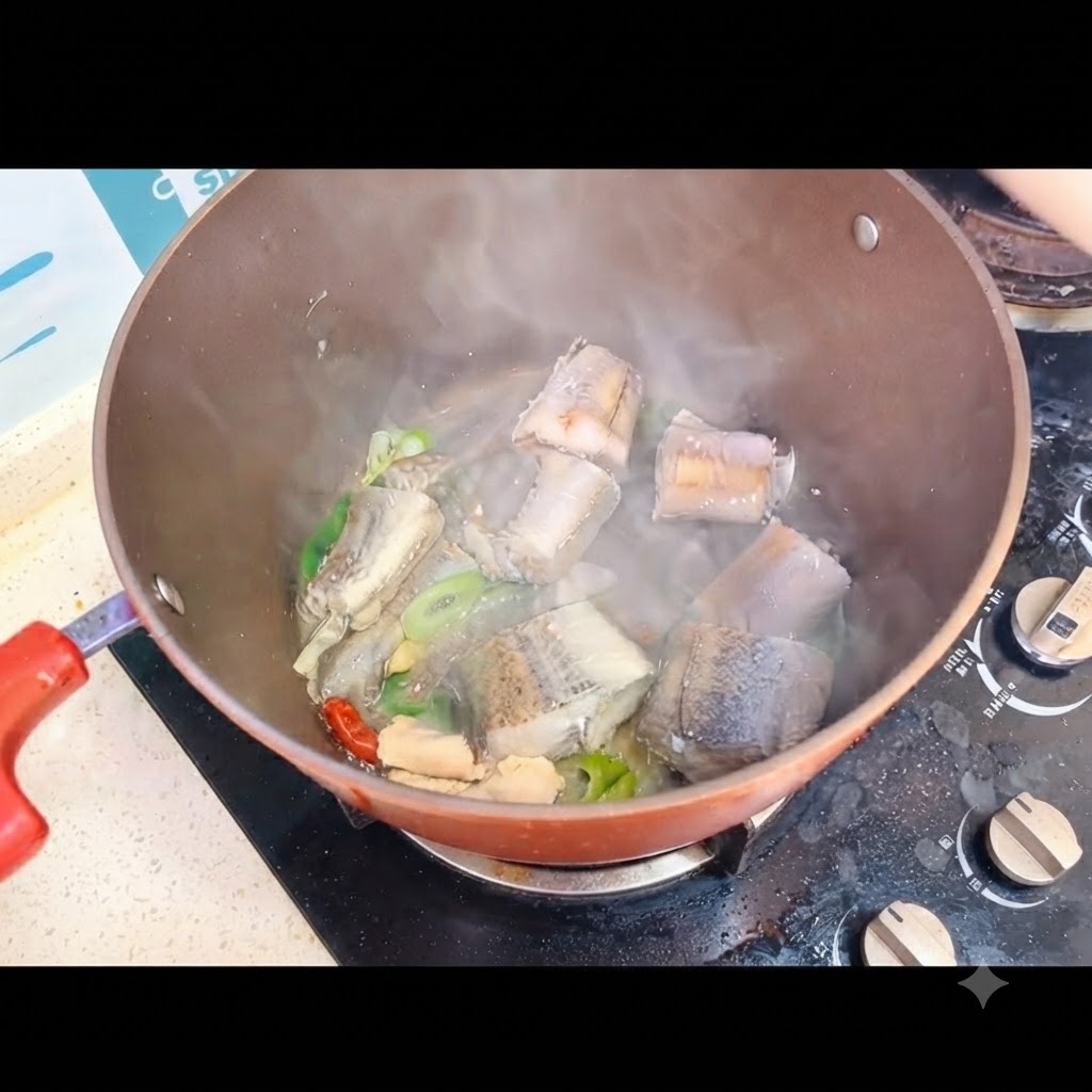Acqua bollente versata sui tranci di pesce allinterno della pentola sul fornello.