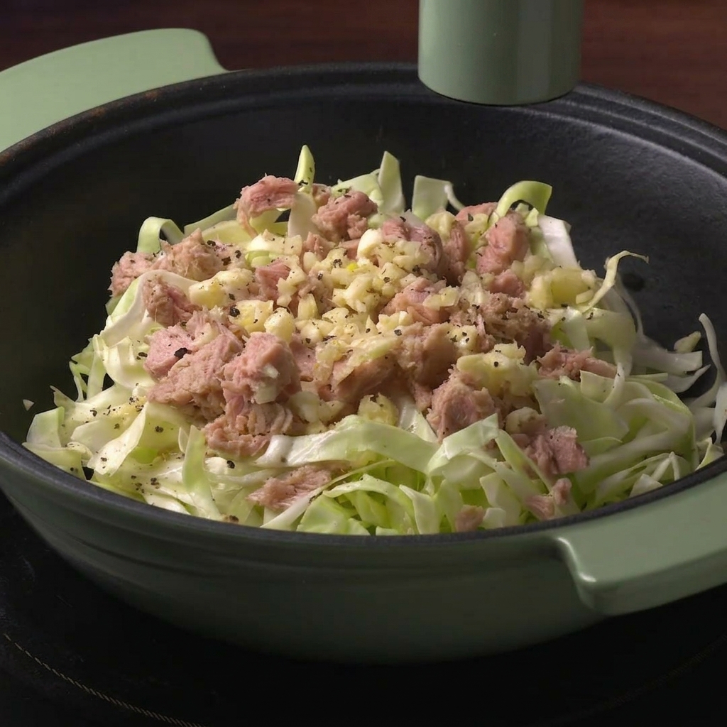 Un macinapepe verde che condisce gli ingredienti allinterno della pentola con pepe nero.