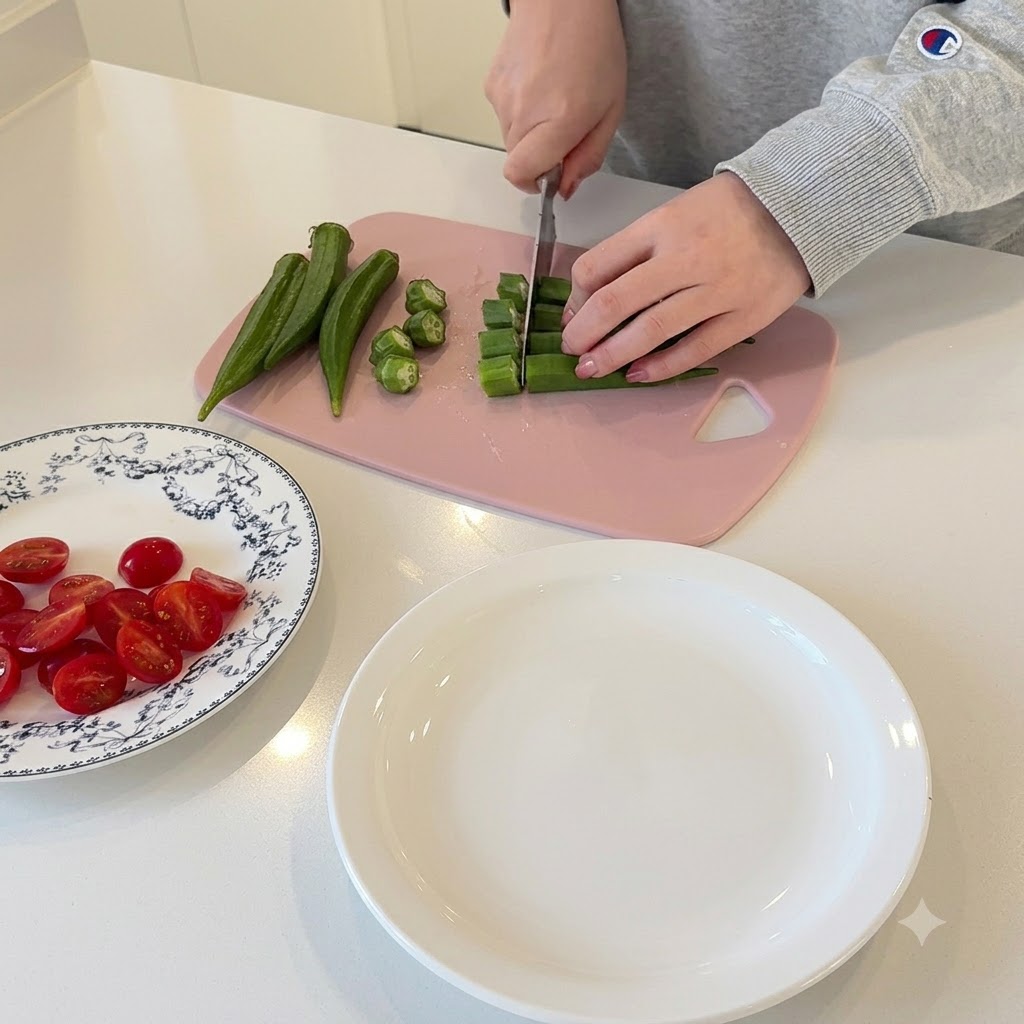 Mani che affettano lokra verde in piccoli pezzi circolari su un tagliere rosa.