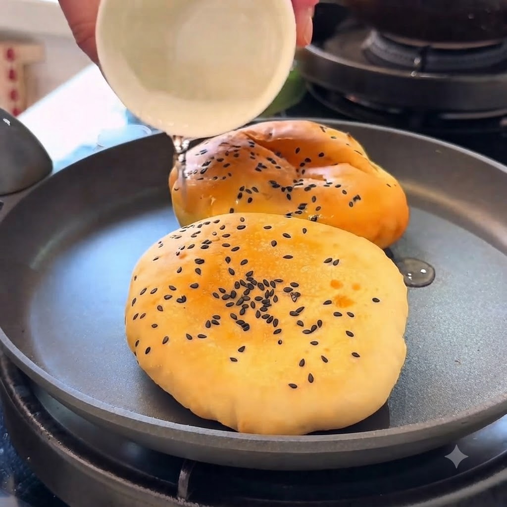 Panini da hamburger riscaldati in padella con acqua mentre sono coperti.
