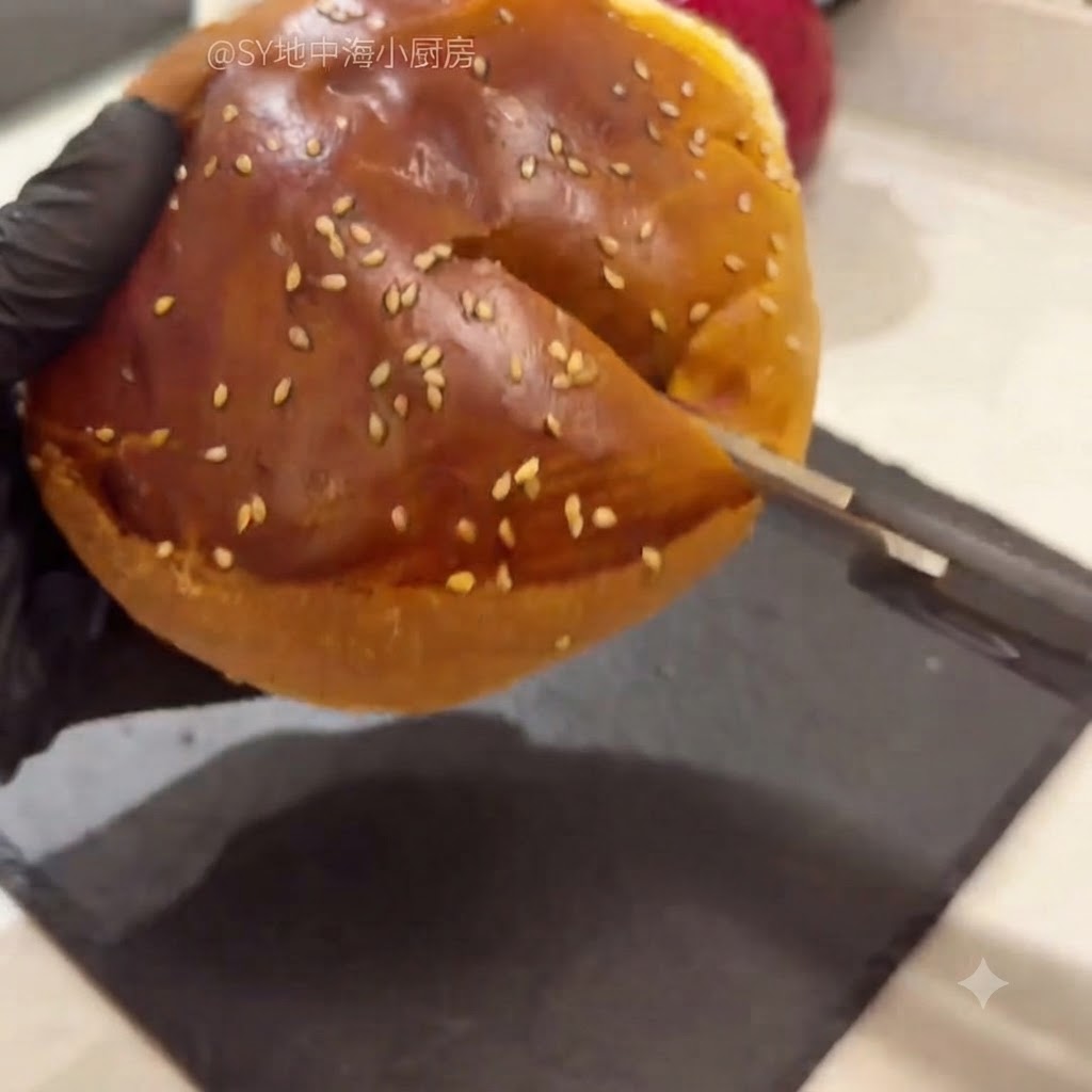 Un panino per hamburger tagliato a metà con le forbici da cucina, con la mollica interna che viene rimossa.