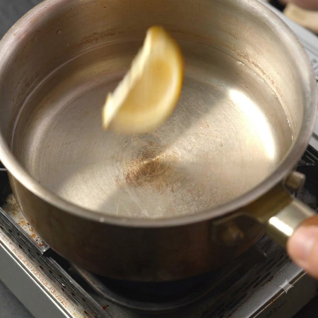 Una singola fettina di limone che cade nella pentola di liquido.